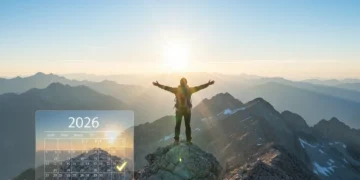Person on mountain peak overlooking 2026, symbolizing successful goal achievement.